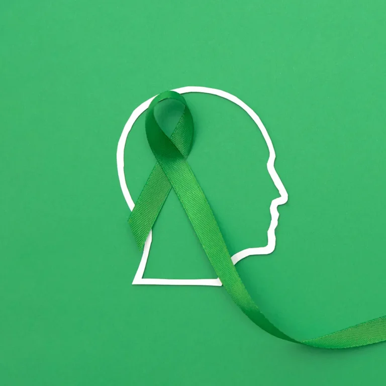 Green mental health awareness ribbon with the outline of a head, promoting a complete guide for National Depression and Mental Health Screening Month